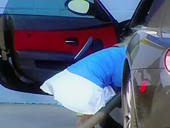 Blonde MILF shows cleavage and ass at the carwash