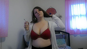 Busty girl smokes and gives a peak