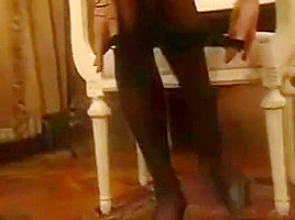 Erica Bella on a bed in black stockings