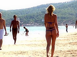 Hot blonde milf posing on public beach in string bikini