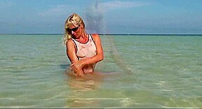 Hot milf posing in wet see through bikini on the beach