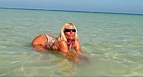 Hot milf posing in wet see through bikini on the beach